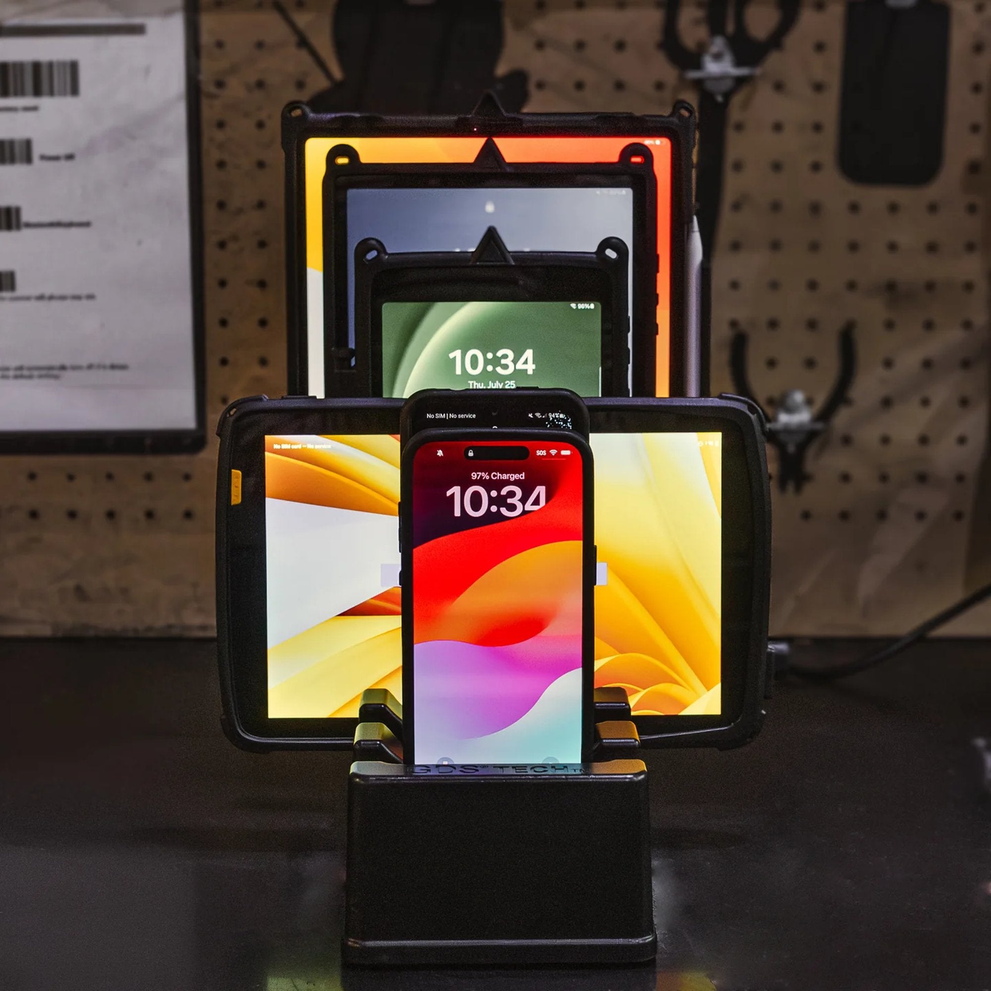 Rugged charging dock powering multiple tablets and phones on workbench